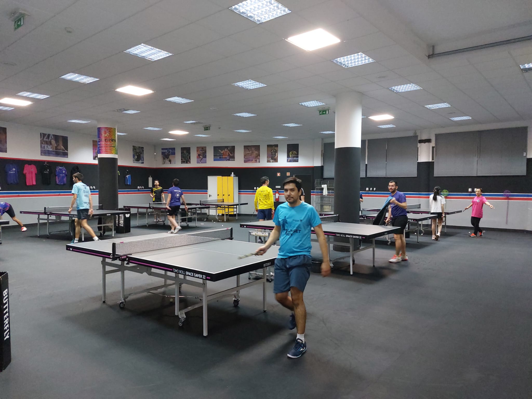 Sala do CTM Coimbra com várias mesas de ténis de mesa durante uma sessão de treino